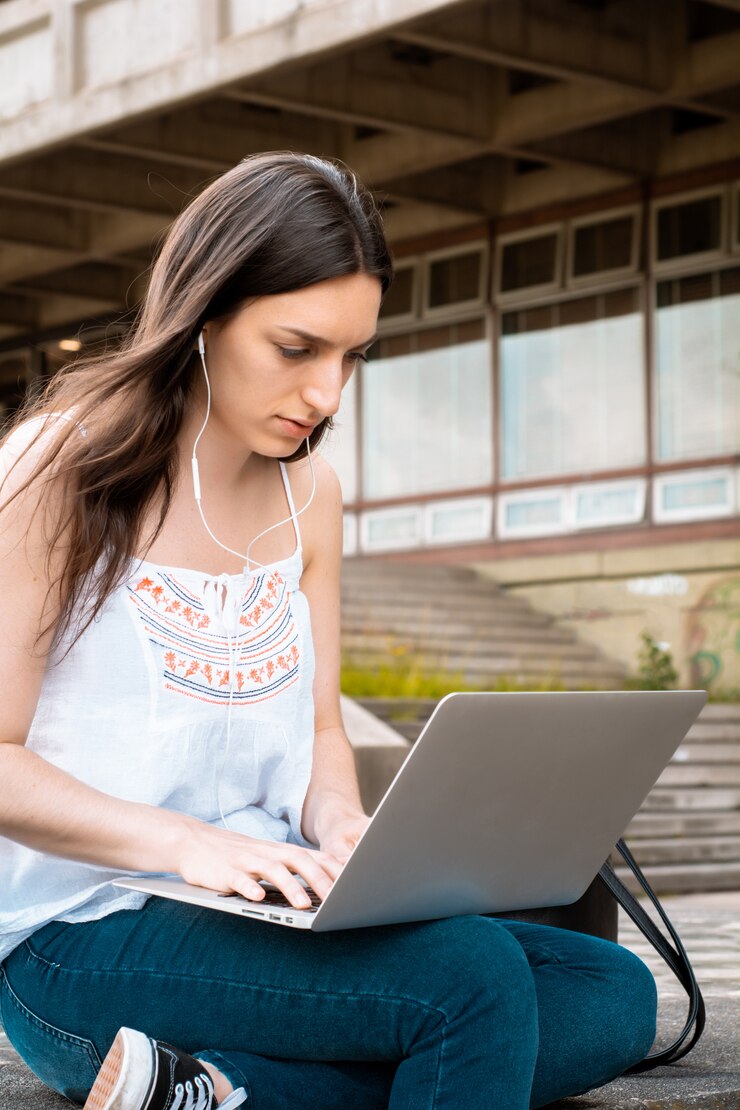 Foto joven estudiante usando laptop al aire libre.