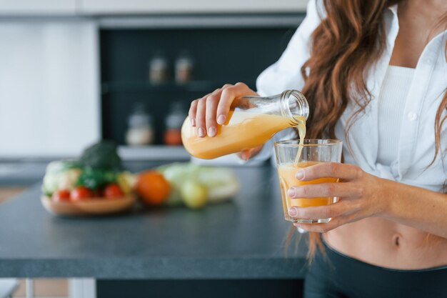 Foto la joven europea está adentro en la cocina adentro con comida saludable