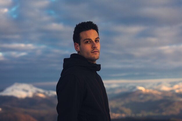 Joven excursionista en la cima de una montaña nevada en invierno.