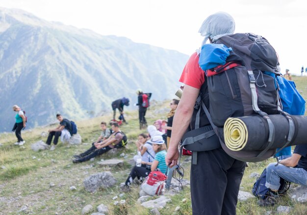 Joven excursionista con mochila y botas grupo líder