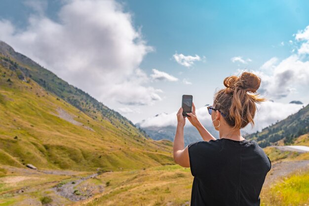 Joven excursionista Mujer tomando una foto con su teléfono celular en la cima de una montaña Discovery Travel Destination Concept
