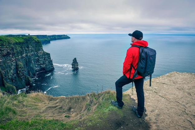 Joven excursionista de pie en los acantilados de moher