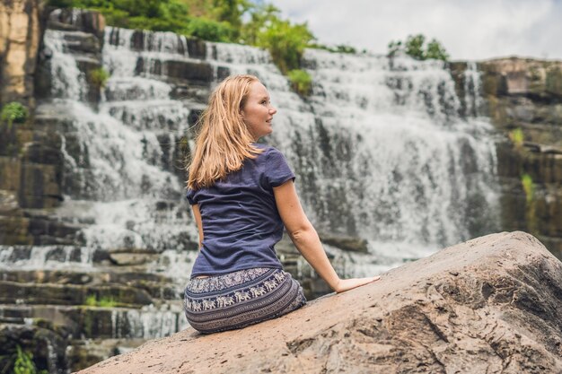 Joven excursionista, turista en la superficie de la increíble cascada Pongour es famosa y la más hermosa del otoño en Vietnam