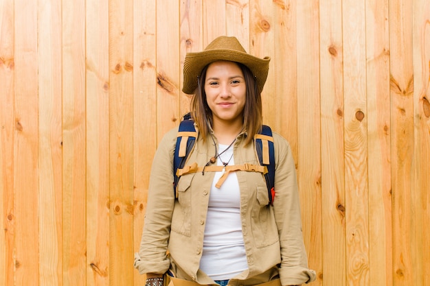 Joven explorador latino mujer pared de madera