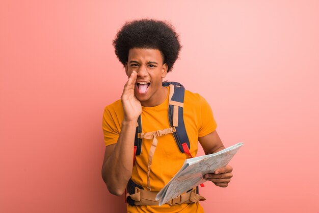 Joven explorador sosteniendo un mapa gritando algo feliz al frente