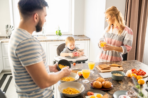 Joven familia disfrutando del desayuno con bebé