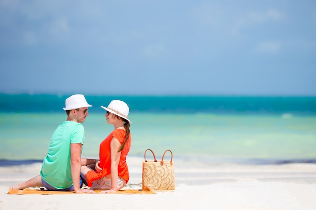 Joven familia de dos en la playa blanca durante las vacaciones de verano