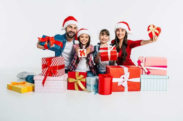 Joven familia feliz con gorro de Papá Noel con regalos de Navidad