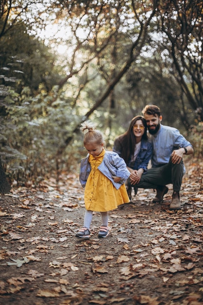 joven familia feliz de hipsters con estilo caminando en el parque de otoño junto con su dulce hija