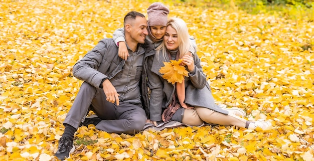 Joven familia feliz mientras camina en el parque de otoño.