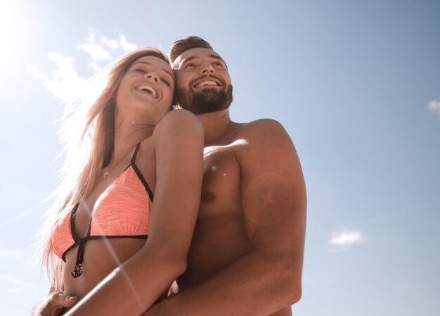 Joven familia feliz mirando al cielo azul