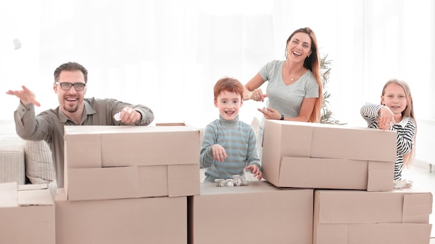 Joven familia feliz de pie en un apartamento nuevo