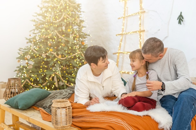 La joven familia feliz se prepara para las celebraciones de Navidad y Adviento.