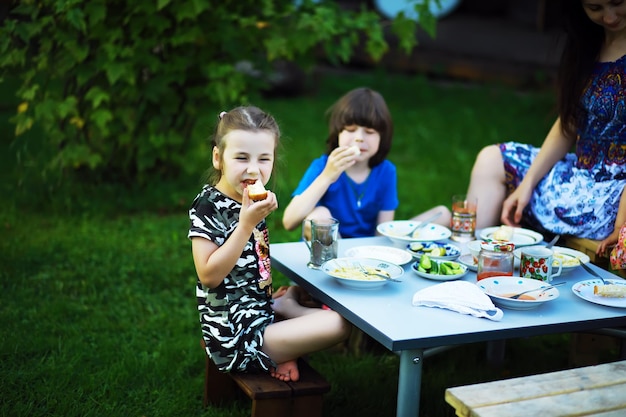 Una joven familia numerosa en un picnic en una mañana de verano Una hermosa madre con hijos está desayunando en el parque