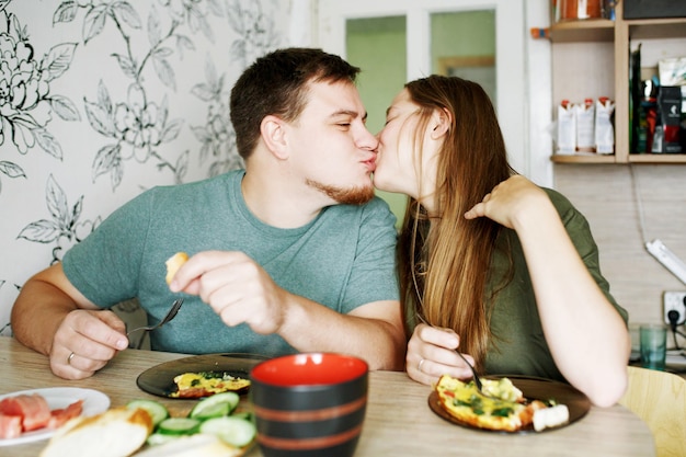 Joven familia sincera desayunando en casa