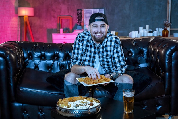 Joven fanático viendo un partido de fútbol en la televisión un nervioso