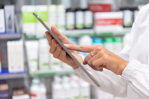 Joven farmacéutico comprobando el inventario en una farmacia