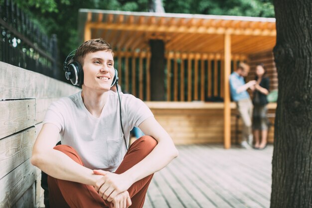 Joven feliz en auriculares al aire libre