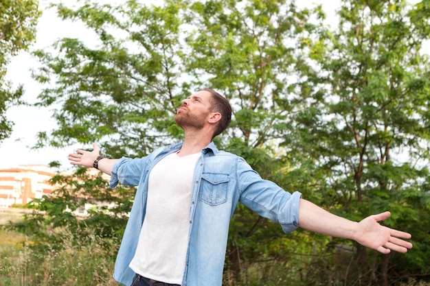 Foto joven feliz con los brazos extendidos contra las plantas