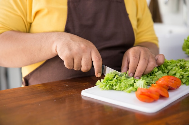 Joven feliz cocinando su comida