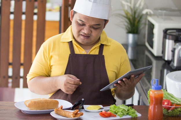 Joven feliz cocinando su comida