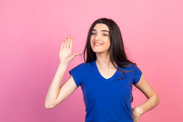 Una joven feliz levantó la mano y sonrió