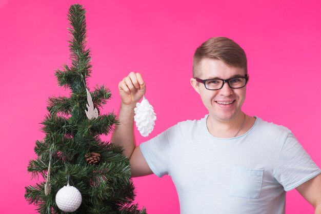 joven feliz mostrar adornos navideños