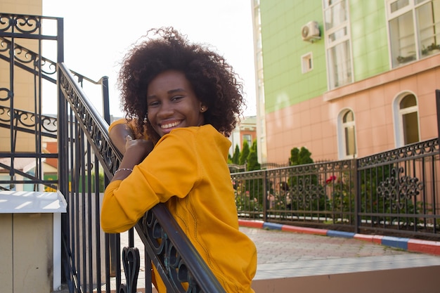Una joven y feliz mujer afroamericana camina por la calle