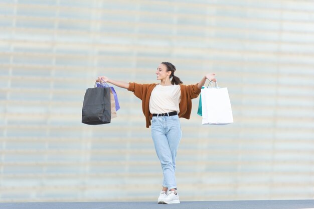 Una joven feliz y orgullosa sosteniendo sus bolsas de compras