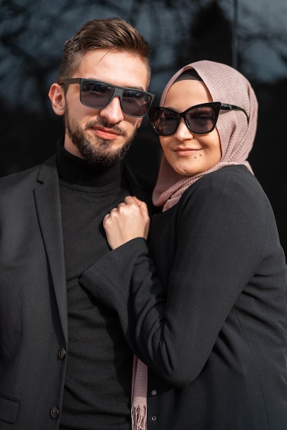 Una joven feliz pareja musulmana de moda posando afuera