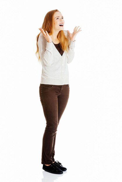 Foto una joven feliz de pie contra un fondo blanco