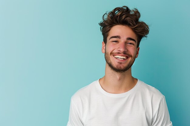 Un joven feliz posando en un estudio con un fondo azul claro