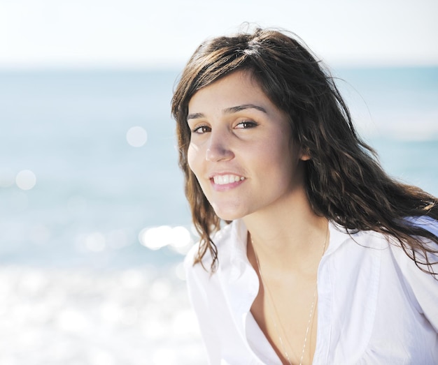 una joven feliz se relaja en una hermosa playa por la mañana