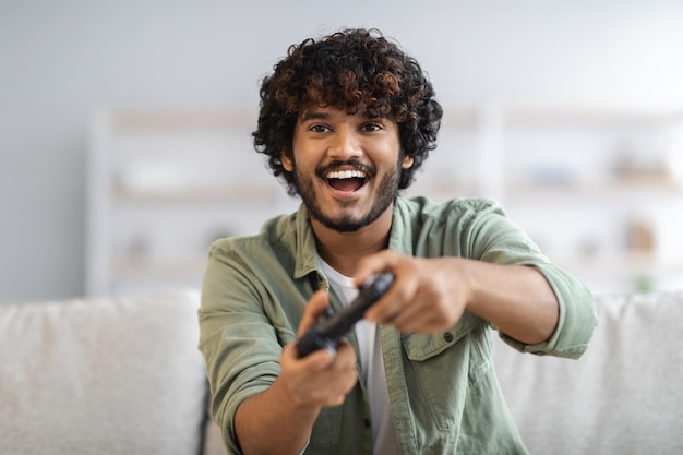 Joven feliz riendo y jugando videojuegos el fin de semana