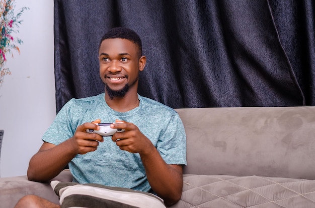 Joven feliz riendo y jugando videojuegos el fin de semana