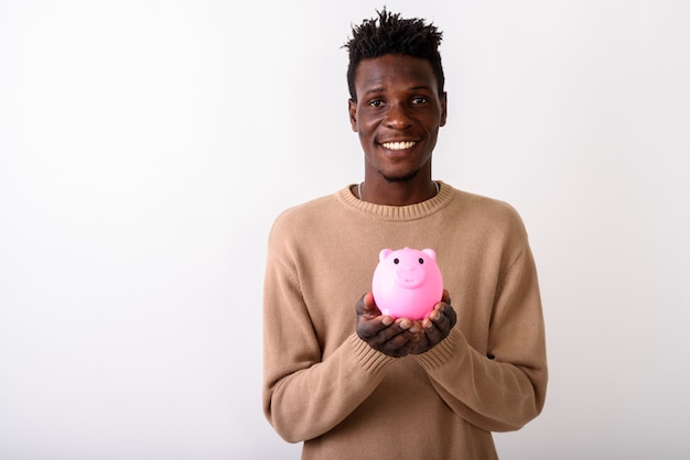 Joven feliz sonriendo mientras sostiene la hucha