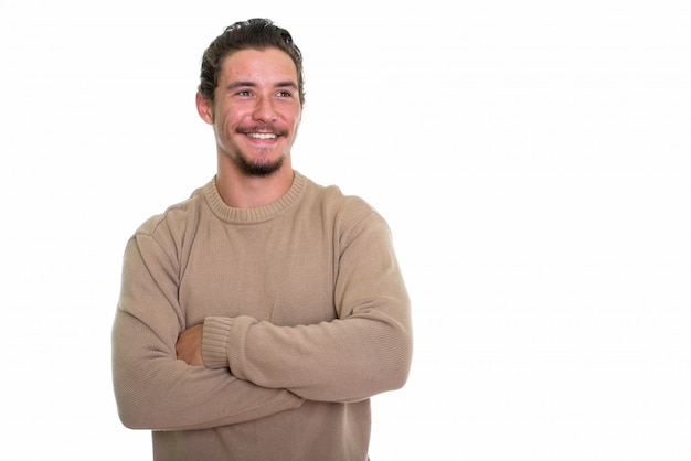 Joven feliz sonriendo y pensando con los brazos cruzados