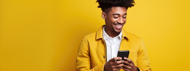 Un joven feliz y sonriente usando su teléfono en un fondo de color