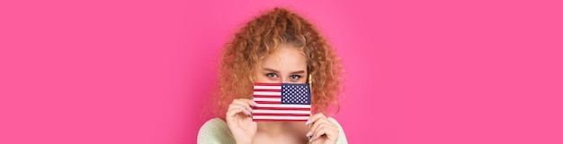 Una joven feliz con una sonrisa en el rostro sostiene una bandera estadounidense en sus manos Símbolo de patriotismo y libertad