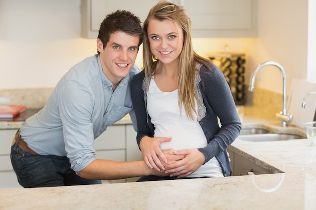 Joven feliz con su esposa embarazada