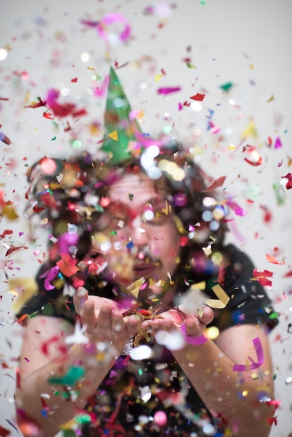 joven en fiesta celebrando año nuevo con confeti cayendo