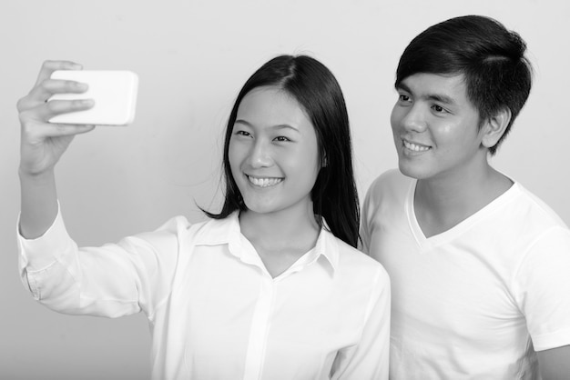 Joven filipino y joven mujer asiática juntos en blanco en blanco y negro