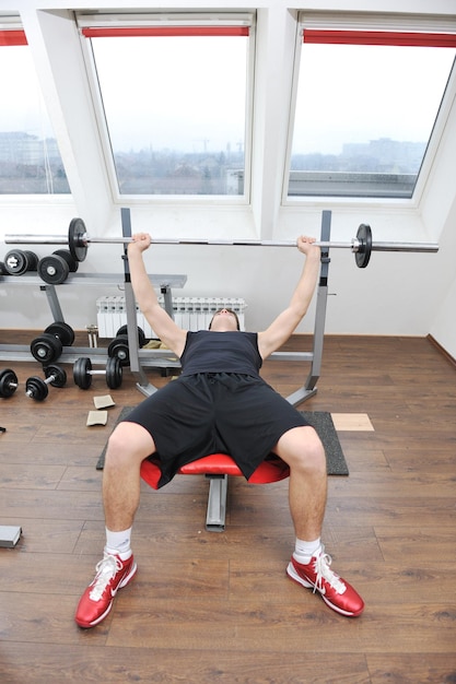 Foto joven en fintess sport club ejercicio con pesas y relajante