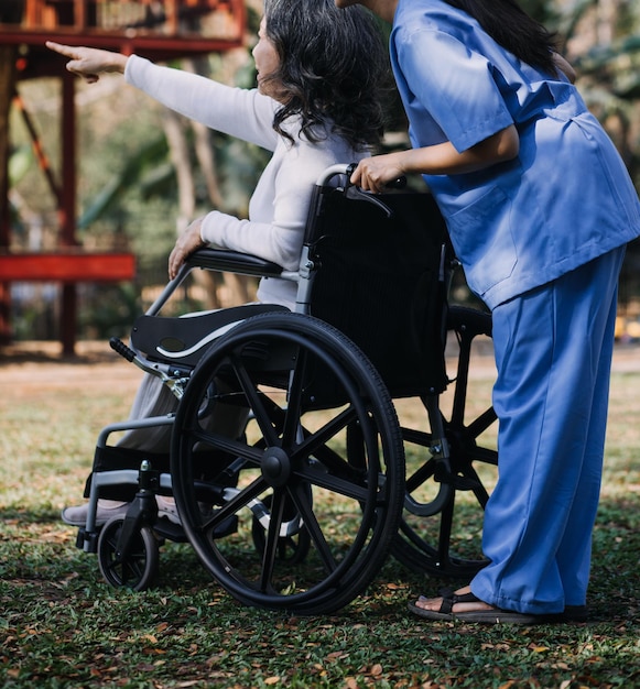 Joven fisioterapeuta asiática que trabaja con una anciana caminando con un andador