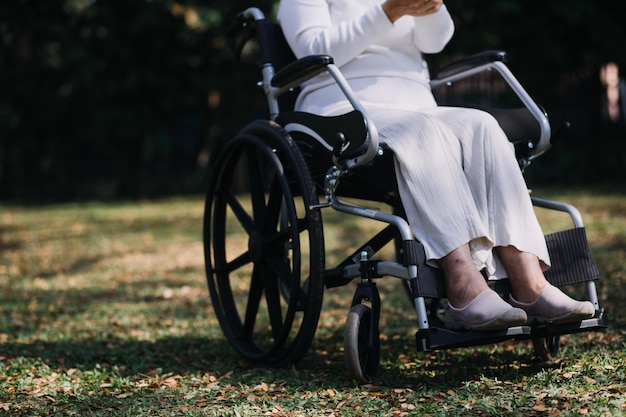 Joven fisioterapeuta asiática que trabaja con una anciana caminando con un andador