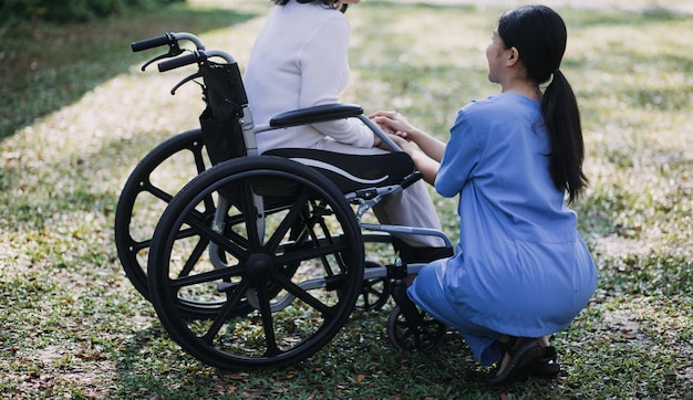 Joven fisioterapeuta asiático trabajando con una mujer mayor en caminar con un andador