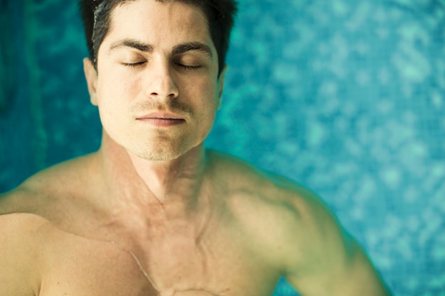 Joven flotando en la piscina