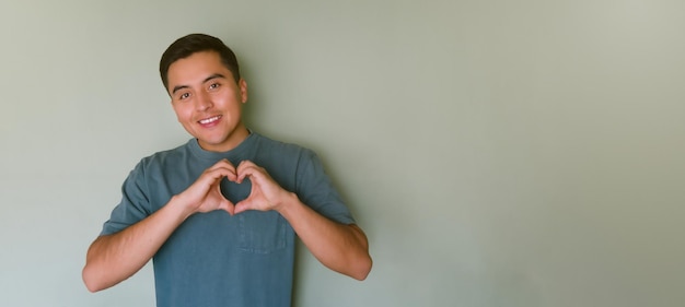 Joven formando un corazón con sus manos con espacio para texto