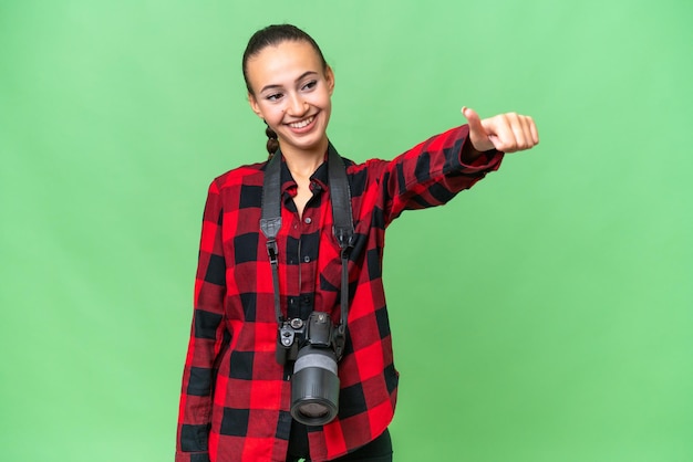 Foto joven fotógrafa árabe sobre un fondo aislado dando un gesto de pulgar hacia arriba