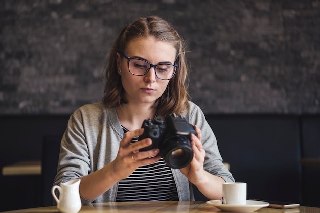 Joven fotógrafa comprobando una imagen mientras se relaja